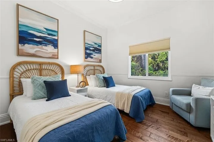 Bedroom with dark wood-style flooring and ornamental molding