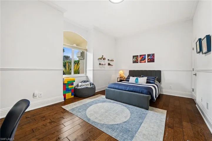 Bedroom featuring dark wood-style floors and crown molding