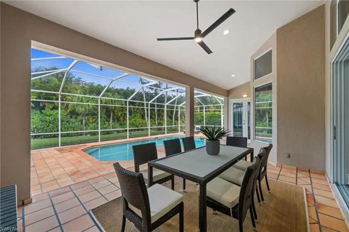 View of patio featuring an outdoor pool, a sunroom, glass enclosure, outdoor dining space, and a ceiling fan