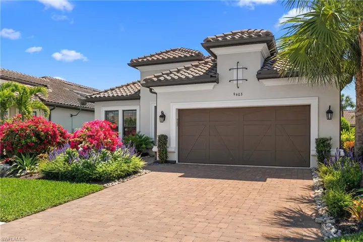 Mediterranean / spanish house with stucco siding, an attached garage, a tile roof, and decorative driveway