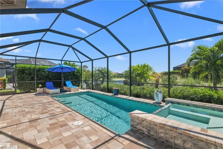 View of pool featuring glass enclosure and a patio area