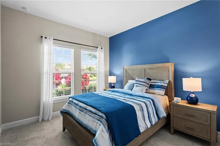 Bedroom with light colored carpet and baseboards
