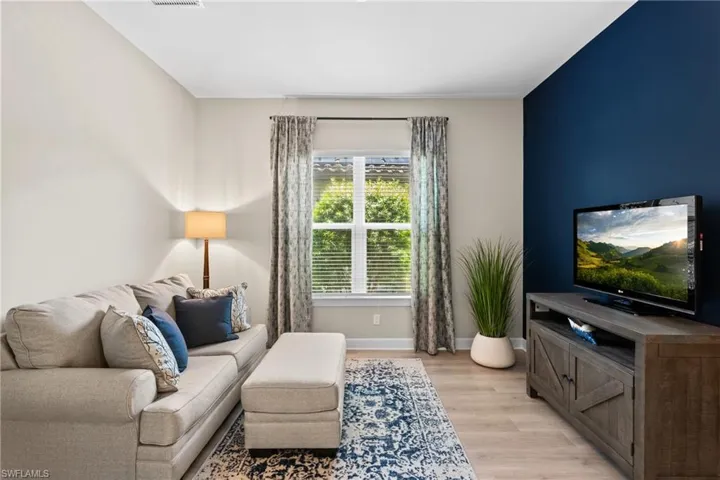 Living room with baseboards, visible vents, and light wood-style floors
