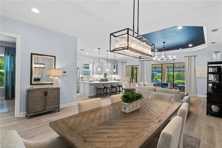 Dining room with a healthy amount of sunlight, visible vents, a chandelier, and light wood-style floors
