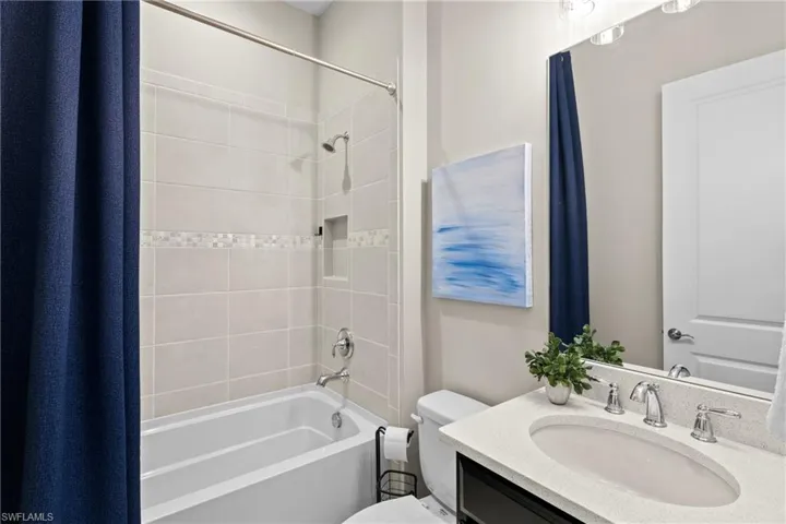 Bathroom featuring toilet, shower / bathing tub combination, and vanity
