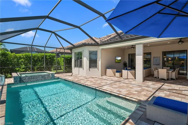 View of swimming pool featuring a ceiling fan, a pool with connected hot tub, a lanai, and a patio area