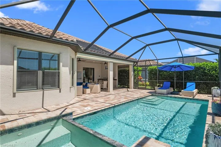 View of swimming pool with a pool with connected hot tub, a lanai, ceiling fan, and a patio