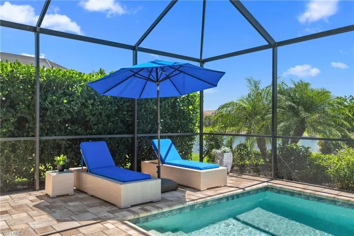 Outdoor pool featuring glass enclosure and a patio