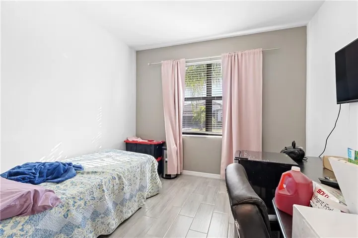 Bedroom featuring baseboards and wood tiled floors