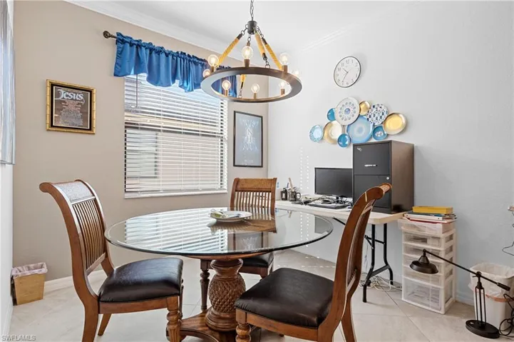 Dining area with a chandelier, ornamental molding, and light tile patterned floors