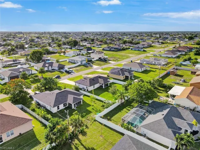 Aerial perspective showcasing a residential area with single-story homes and undeveloped lots
