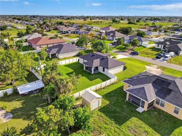 Aerial perspective showcasing a residential neighborhood with single-story homes, many featuring dark shingle roofs and light-colored exteriors