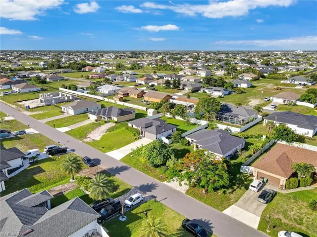 Aerial perspective showcasing a residential neighborhood with single-story homes, many featuring private screened pools