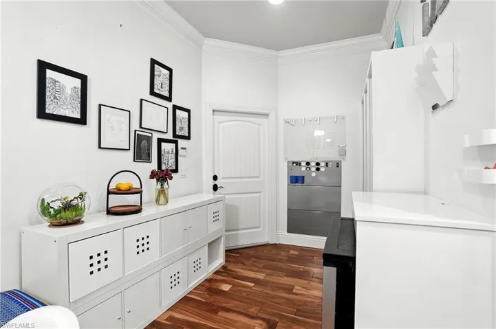 Bathroom featuring ornamental molding, dark wood-type flooring, and vanity - Virtually Edited Image