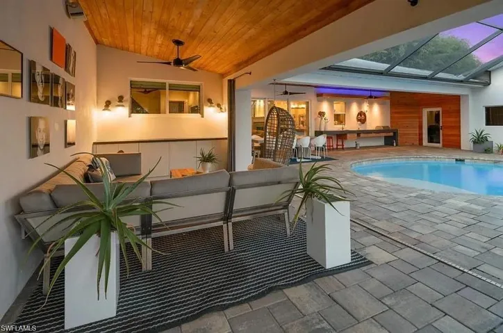 Swimming pool featuring a patio, an outdoor hangout area, and a lanai - Virtually Edited Image