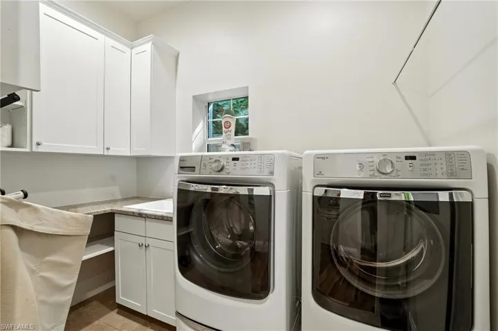 Laundry area with washer and clothes dryer and cabinet space - Virtually Edited Image