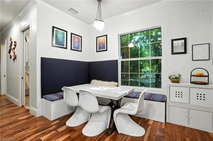 Dining area with ornamental molding and dark wood-type flooring - Virtually Edited Image