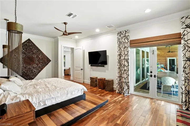 Bedroom featuring crown molding, wood finished floors, a ceiling fan, access to outside, and recessed lighting - Virtually Edited Image