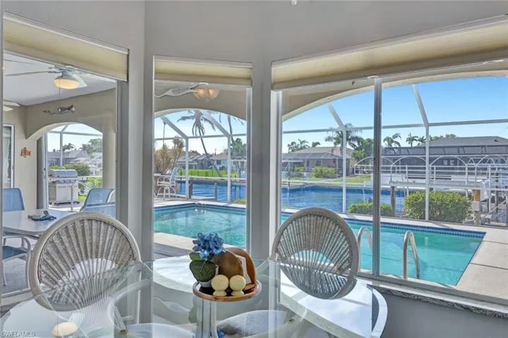 View of pool featuring a water view, ceiling fan, and a grill
