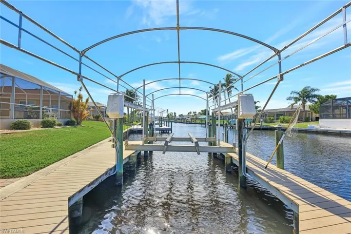 Dock area with a lawn and a water view