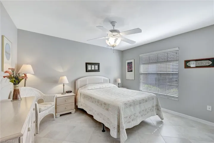 Bedroom with light tile patterned floors and ceiling fan