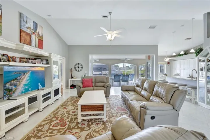 Tiled living room featuring vaulted ceiling