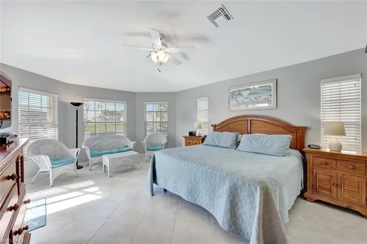 Tiled bedroom featuring ceiling fan