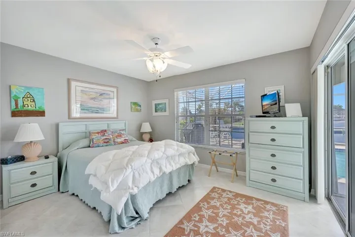 Tiled bedroom featuring access to exterior and ceiling fan