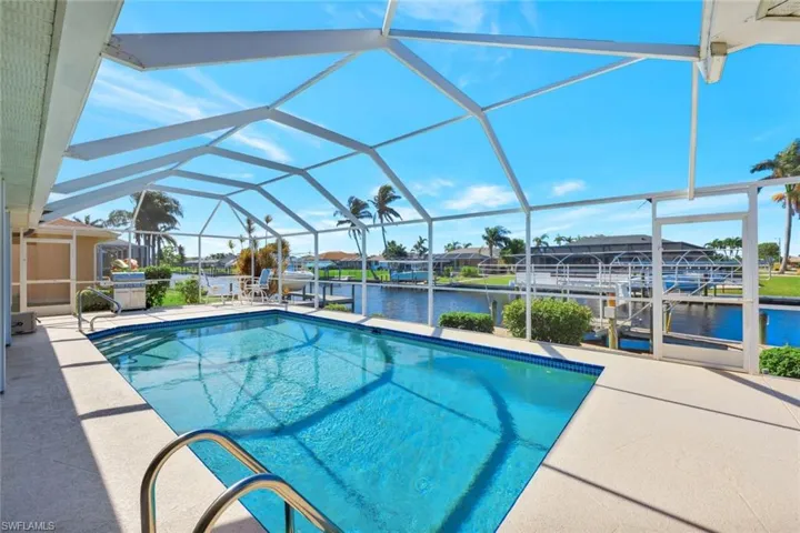 View of swimming pool featuring a water view, a dock, and a lanai