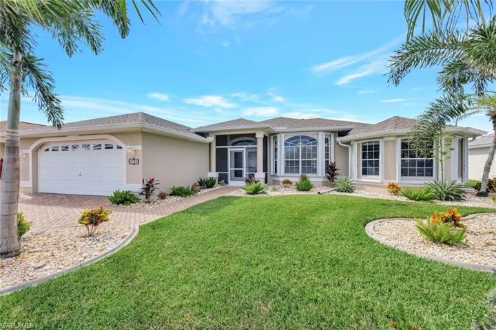 Single story home featuring a front yard, a garage, and a sunroom