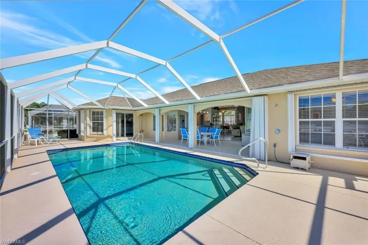 View of pool featuring glass enclosure and a patio