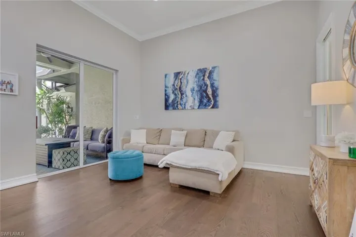 Living room featuring wood finished floors and crown molding