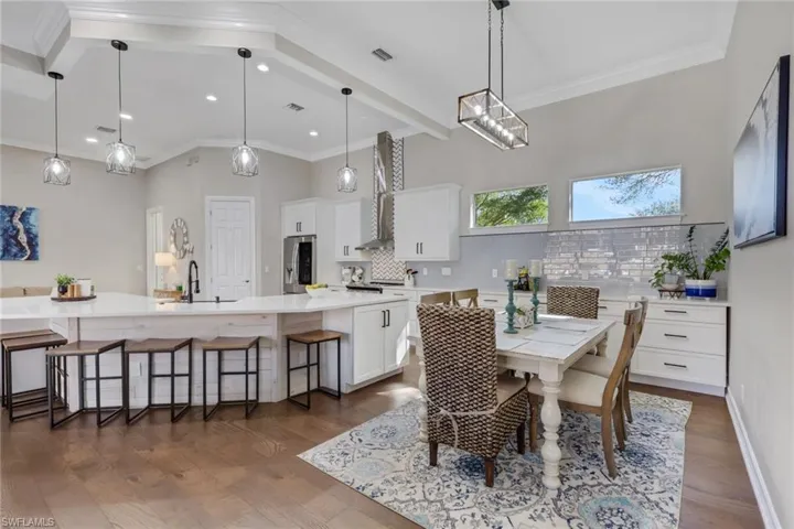 Dining room with crown molding and dark wood-style flooring