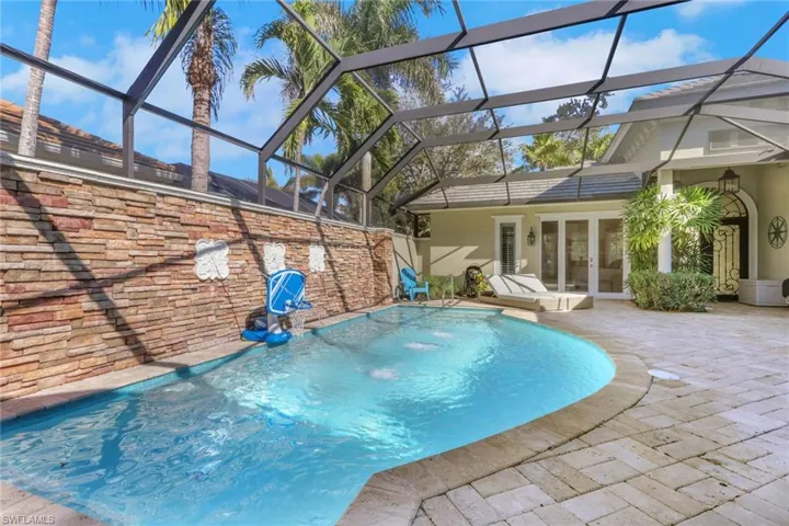 Swimming pool with french doors, a sunroom, a lanai, and a patio area