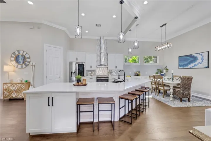Kitchen with white cabinetry, stainless steel appliances, recessed lighting, a spacious island, and hanging light fixtures