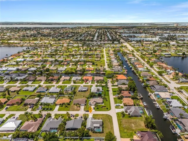 Aerial perspective showcasing a residential community with numerous properties featuring individual green lawns