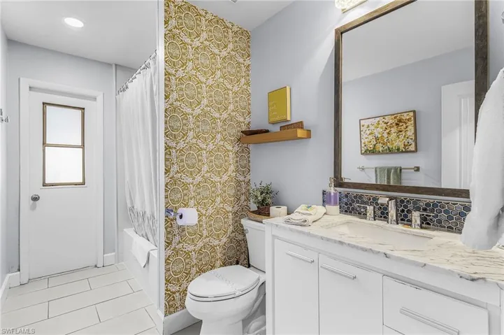 Bathroom featuring a vanity with a light-toned countertop, white cabinetry, and an undermount sink