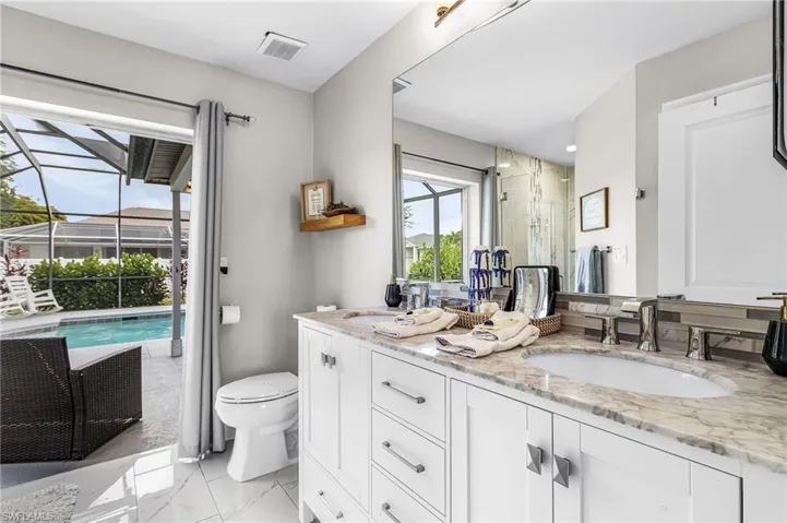 Dual sink vanity with stone countertop and polished chrome fixtures