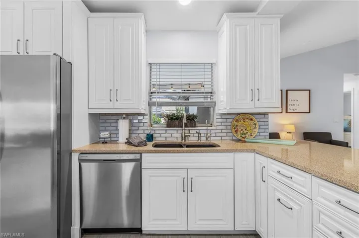Kitchen featuring white cabinetry and light-toned countertops