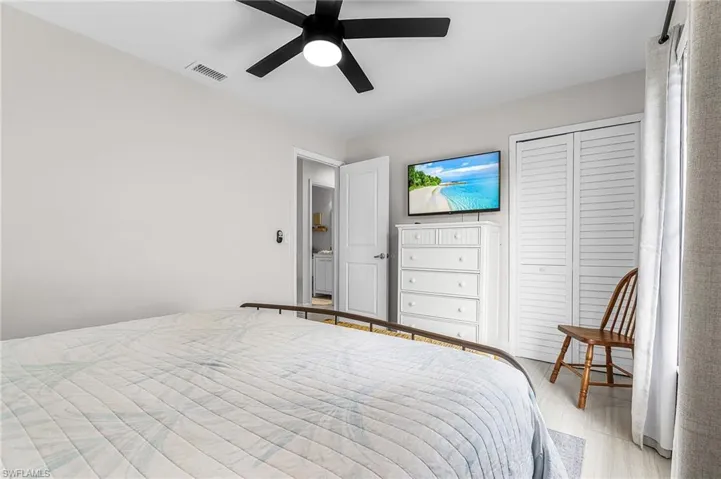 Interior room with a ceiling fan, light gray walls, and light wood-finish flooring