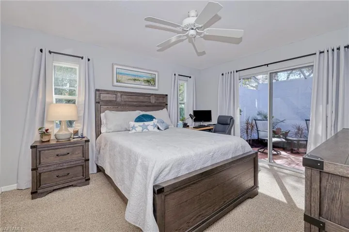 Carpeted bedroom featuring access to outside and ceiling fan
