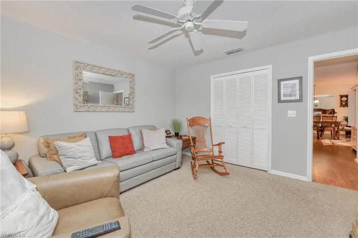 Living room with carpet flooring and ceiling fan