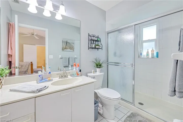Bathroom featuring tile patterned floors, vanity, toilet, and a shower with shower door