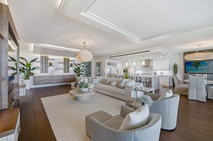 Expansive living space featuring dark wood-finish flooring and a light-toned area rug