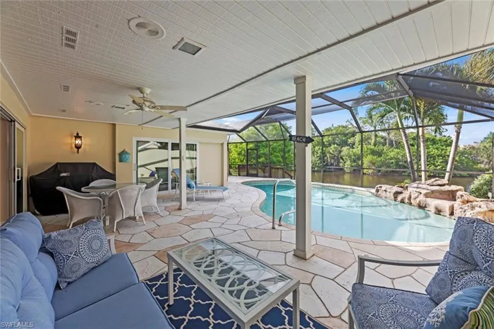 View of pool featuring a patio, glass enclosure, and an outdoor hangout area