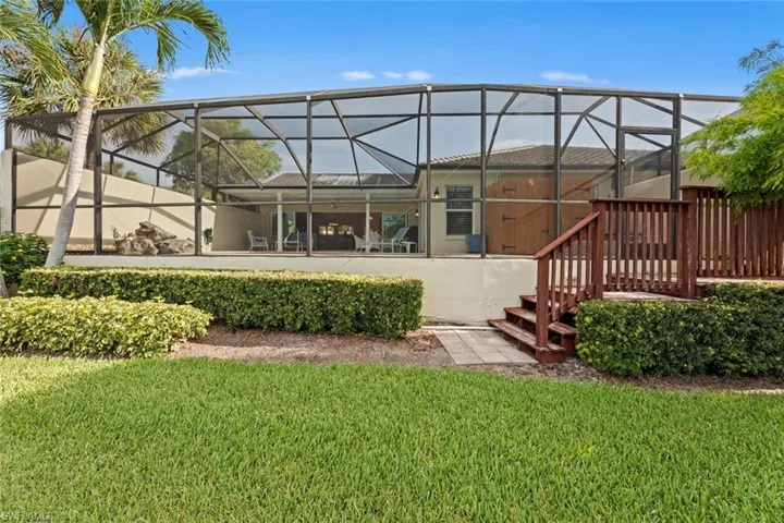 Back of property with a yard and a lanai
