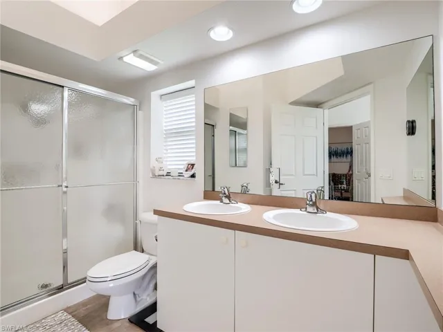 Bathroom featuring double vanity and a shower stall