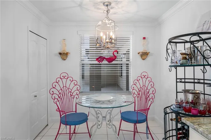 Dining area featuring a chandelier, light tile patterned floors, baseboards, and ornamental molding