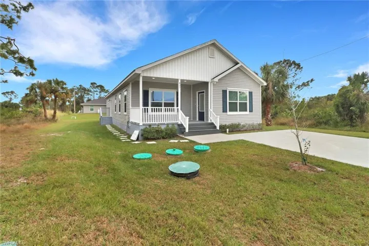 View of front of home with a porch and a front yard