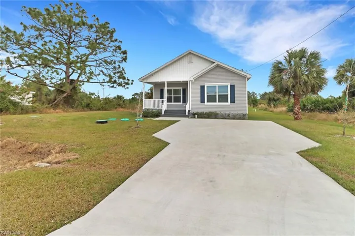 View of front of home with a porch and a front lawn